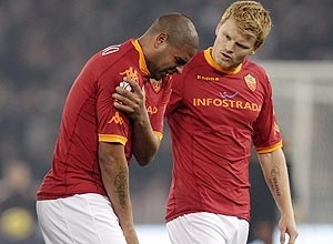 Adriano coloca a mo na regio perto do ombro direito observado pelo zagueiro noruegus da Roma John Arne Riise 