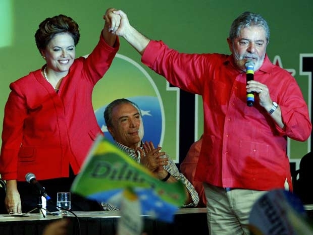 Dilma e Lula do as mos na conveno do PT, em Braslia, observados pelo candidato a vice, Michel Temer.
