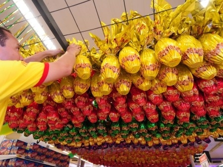 Profissional monta estande de vendas de ovos de chocolate em supermercado