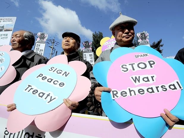 Ativistas sul-coreanos seguram cartazes durante manifestao contra o incio do exerccio militar conjunto dos EUA e da