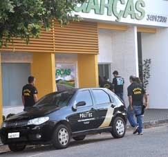 Policiais civis cumprem um mandado de busca e apreenso em Barra do Garas, epicentro da fraude