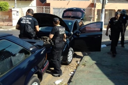 Policiais civis fazem a averiguao em um dos carros  venda