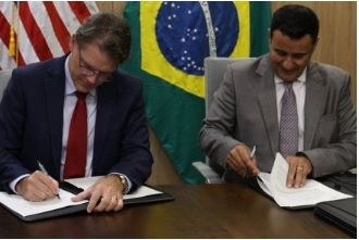 O promotor Mauro Zaque, em Braslia, assinando o documento ao lado do representante norte-americano