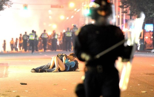 Scott Jones e Alexandra Thomas se beijam no asfalto durante tumulto, na foto que teve repercusso em todo o mundo