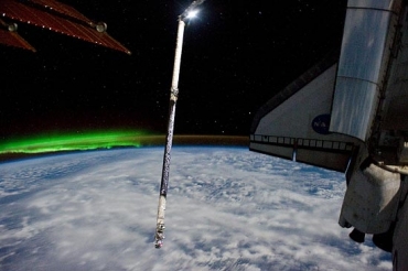 Luz verde da aurora austral pode ser vista  esquerda do Atlantis