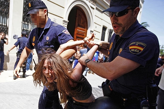 Agentes da Polcia Nacional levam uma das manifestantes que protestava diante do Parlamento de Valencia