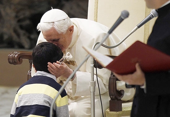 Papa Bento 16 beija menino que passou pela segurana e conseguiu chegar a ele, durante audincia no Vaticano