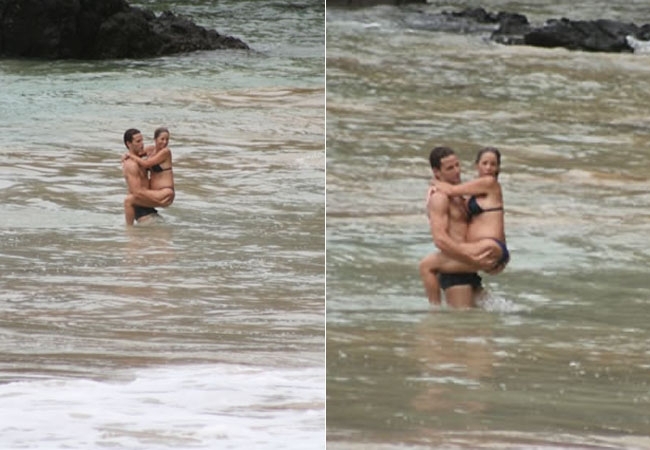 Danielle pula no colo do marido dentro do mar