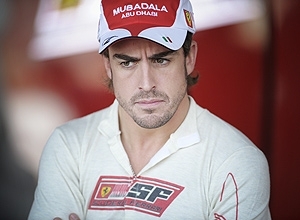 Alonso observa movimentao nos boxes da Ferrari