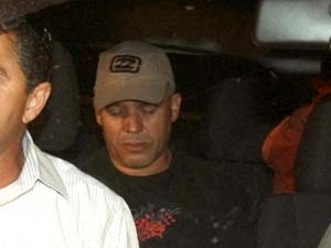 O ex-policial Marcos Aparecido dos Santos (de bon), chega ao Departamento de Investigao