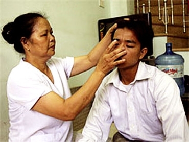 Pham Thi Hong atende um de seus pacientes