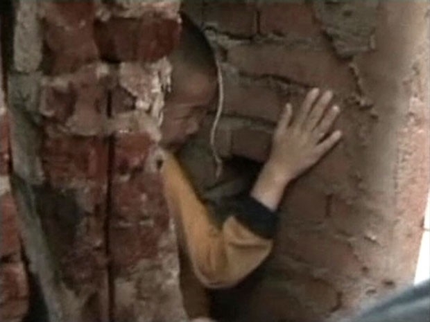 Imagem de TV chinesa mostra menino de 5 anos preso em fenda entre paredes na China