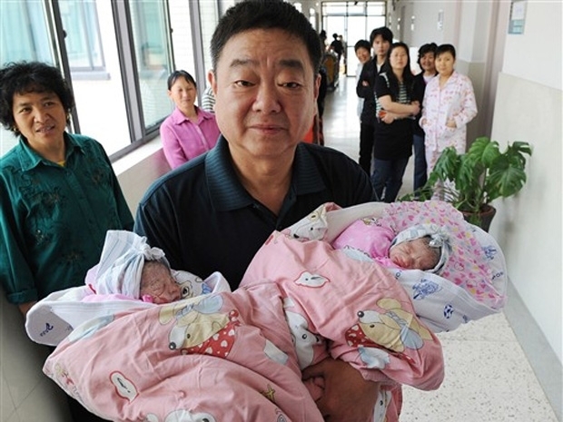 O pai, Wu Jingzhou, exibe suas duas filhas gmeas.