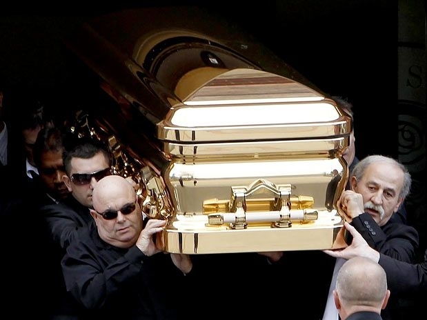 Familiares e amigos carregam caixo de ouro contendo os restos mortais de Carl Williams, em Essedon
