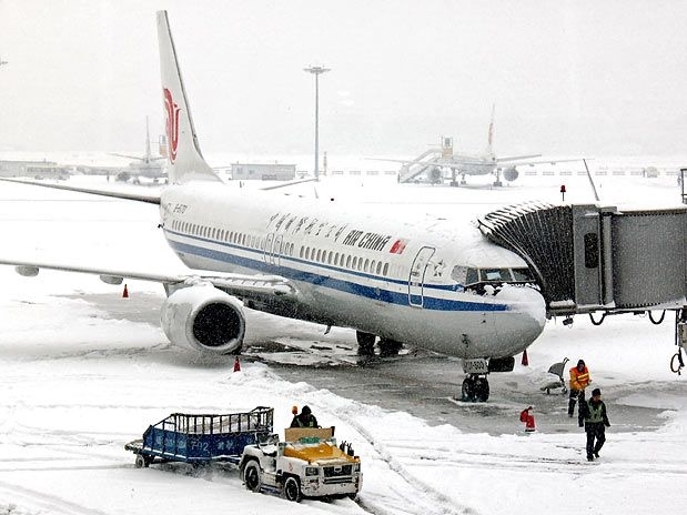 Trabalhadores limpam a neve da pista em Pequim