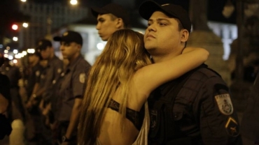 Jovem abraa policial em frente  Alerj durante protesto no Rio de Janeiro