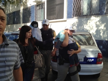 Mulher (com rosto coberto)  detida por suspeita de vender criana de um ano e dois meses.