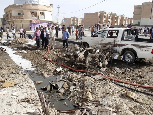 Policiais iraquianos observam local de um ataque a bomba em Kirkuk nesta segunda-feira (15)