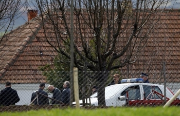 Policiais em frente ao local do crime nesta tera-feira (9) na localidade srvia de Velika Ivanca