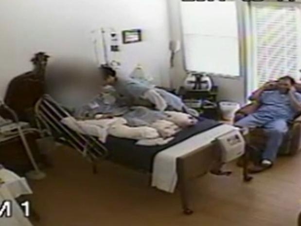 Frame de vdeo mostra momento em que um dos enfermeiros se abaixa para beijar a idosa