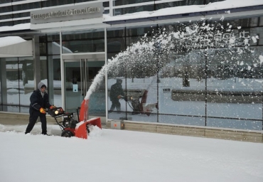 Homem usa equipamento para remover neve e abrir caminho em calada de Washington DC