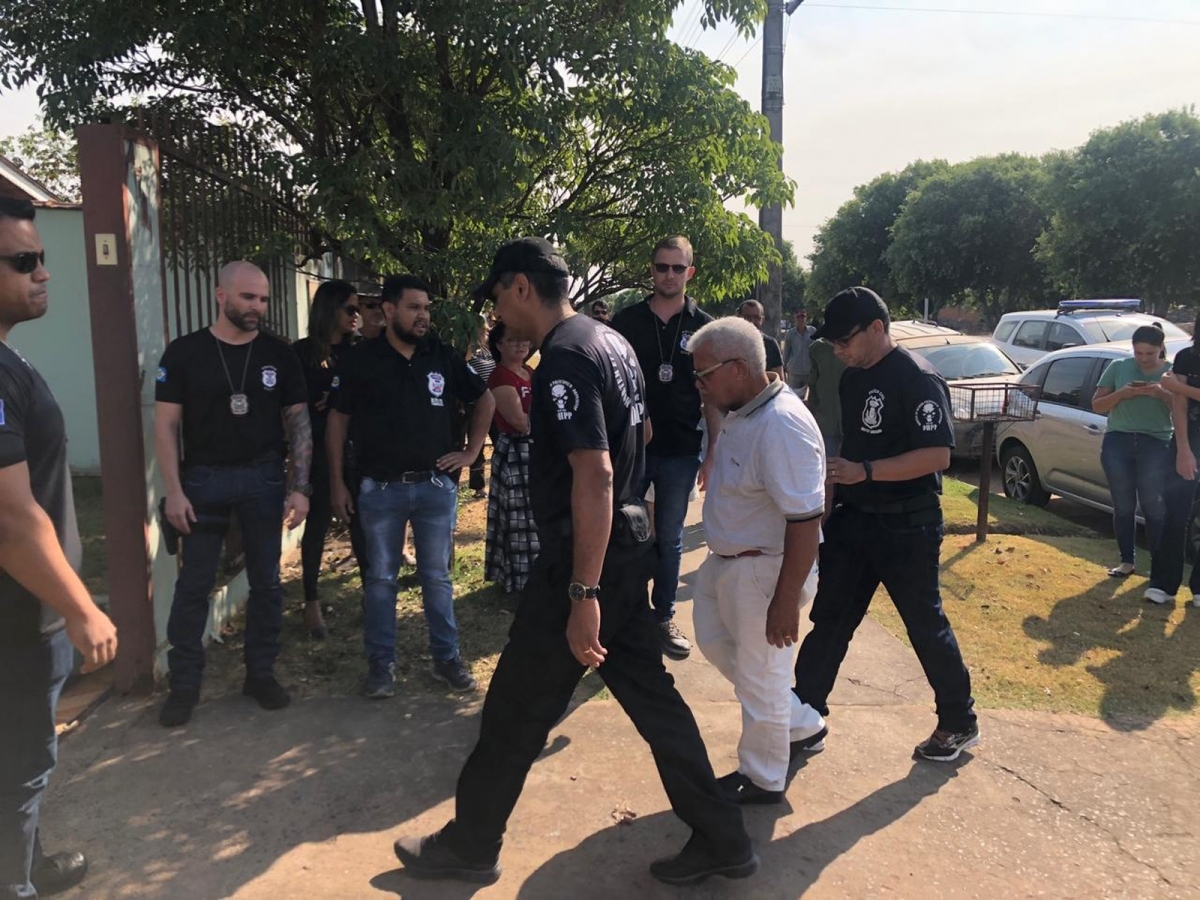 Jairo Narciso da Silva (de branco), de 64 anos, chegou escoltado por policiais para acompanhar a escavao dos restos mortais da mulher dele em Sinop  Foto: Poliana Mazzo/TV Centro Amrica