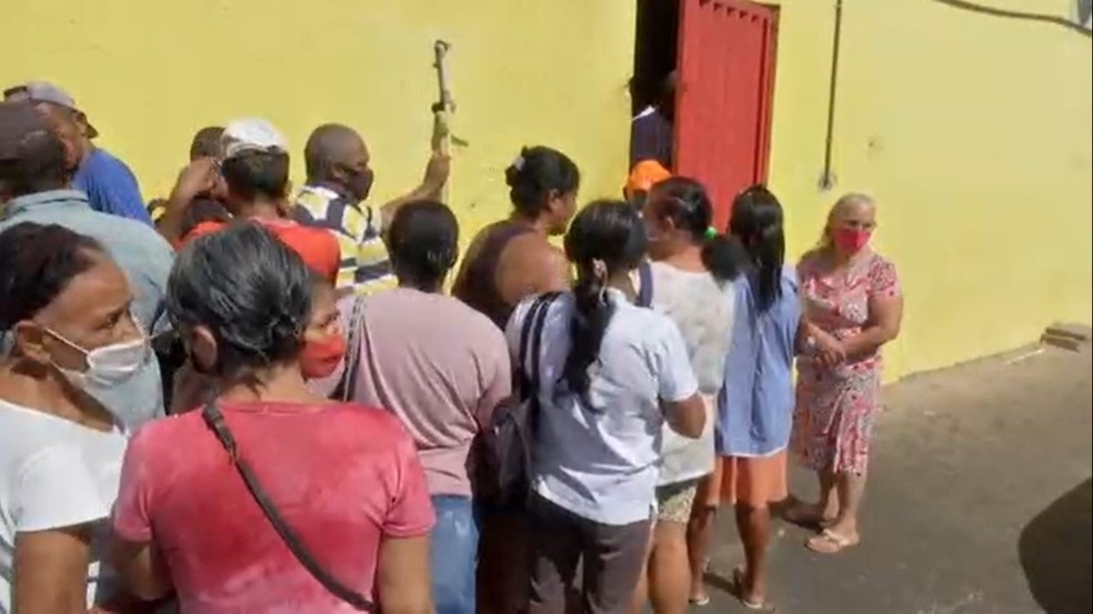 Famlias carentes fazem fila em frente a aougue em Cuiab para receber doao de ossos  Foto: TV Centro Amrica