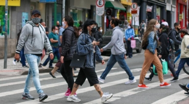 Pedestres caminham de mscara em Curitiba em meio  pandemia de Covid-19