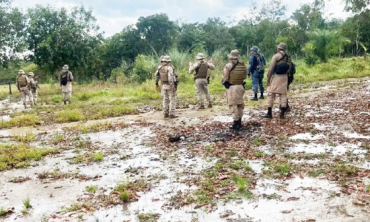 Policiais militares fazem buscas por criminosos em rea alagada, na zona rural do Tocantins