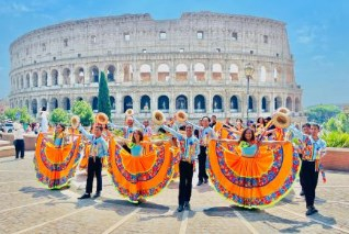 Integrantes do Grupo Flor de Atalaia performam com trajes tpicos em frente ao Coliseu