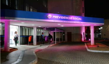 Fachada do prdio da Direo Central do INSS com iluminao prestigiando o Outubro Rosa