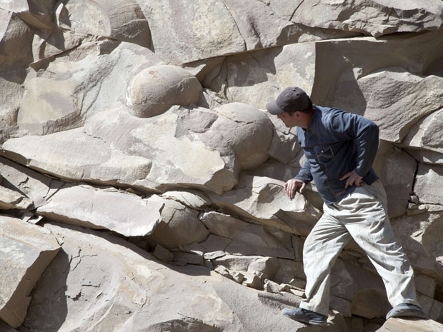 Homem observa ossos de dinossauros fossilizados na regio da Chechnia.