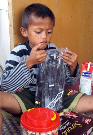 O menino Ilham, de 8 anos,  visto brincando em sua casa em Bogor.