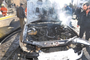 Carro destrudo nos ataques deste sbado (17) em Damasco, capital da Sria 