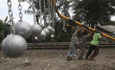 Operrios instalam as bolas de concreto em Bekasi nesta tera-feira (17).