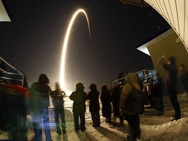 Pessoas assistem ao lanamento da Soyuz na base de Baikonur, no Cazaquisto.