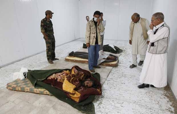 Moradores observam os corpos de Kadhafi, Muatassim e do chefe militar do antigo regime, nesta segunda-feira (24), em Mis