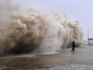 Homem foge de onda gigante provocada pela passagem do tufo por Shantou, no domingo