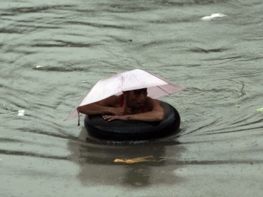Homem tenta se proteger de inundao nas Filipinas
