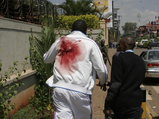 Homem ferido deixa local do ataque no shopping Westgate Mall, no Qunia