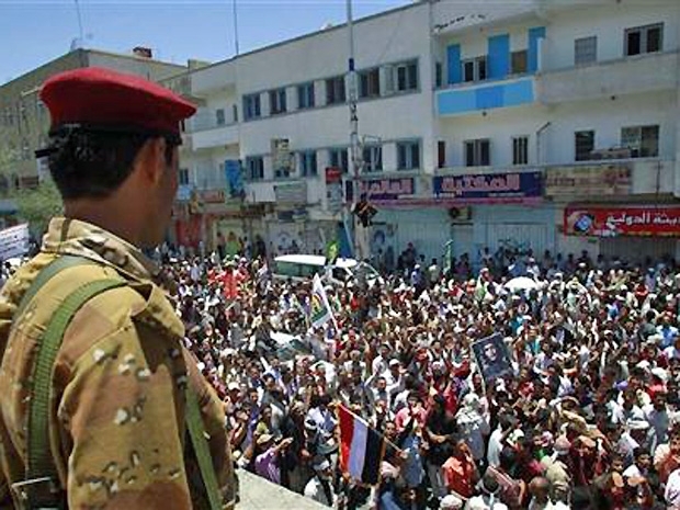 Soldado observa manifestantes pedindo a sada do presidente do Imen, Ali Abdullah Saleh, em Taiz