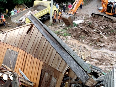 Bombeiros procuram por moradores que foram soterrados em um deslizamento de terra, em Igrejinha