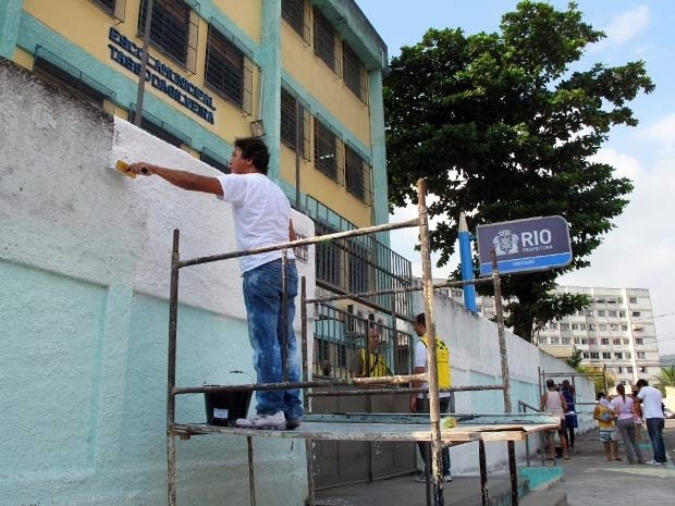 Gerbatim ajuda na pintura do muro da escola onde ocorreu o massacre de Realengo