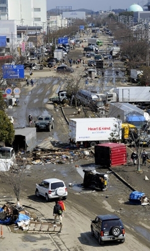 Destroos em rua afetada pelo terremoto na cidade de Tagajo, na prefeitura de Miyagi, neste domingo (13)