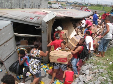 Caminho  saqueado aps tombar em ala de acesso da Rodovia Ferno Dias